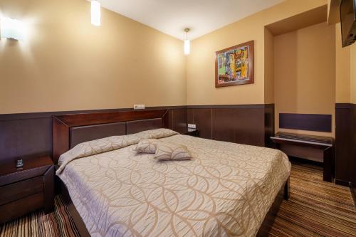 a bedroom with a bed with two towels on it at Hotel Ego - Free Parking - Top Central Location in Plovdiv