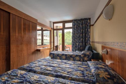 a hotel room with two beds and a window at Hotel Royal in Garda