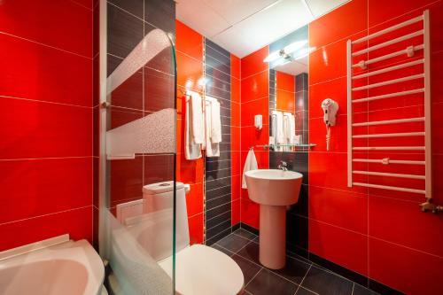 a red bathroom with a toilet and a sink at Hotel Ego - Free Parking - Top Central Location in Plovdiv
