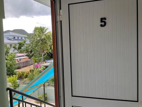 a door with the number on it next to a balcony at Royale Self Catering Apartments in Anse Royale