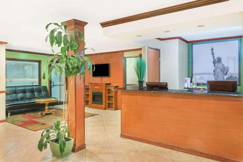 a lobby with a bar with a couch and a tv at Super 8 by Wyndham Tilton/Lake Winnipesaukee in Tilton