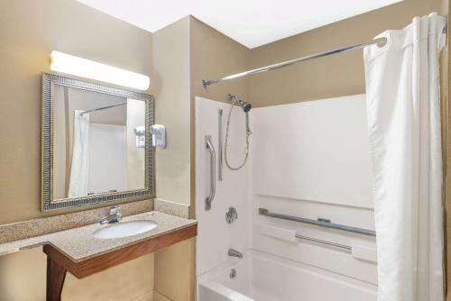 a bathroom with a sink and a mirror and a shower at Super 8 by Wyndham Tilton/Lake Winnipesaukee in Tilton