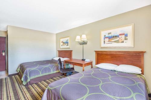 a hotel room with two beds and a desk at Super 8 by Wyndham Tilton/Lake Winnipesaukee in Tilton