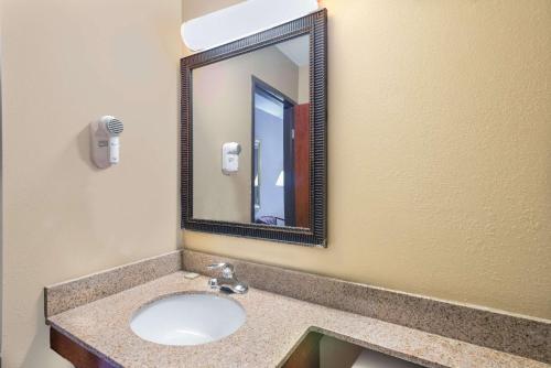 a bathroom with a sink and a mirror at Super 8 by Wyndham Tilton/Lake Winnipesaukee in Tilton