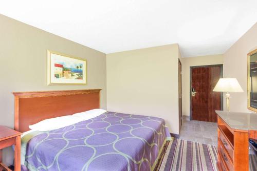 a hotel room with a bed and a desk at Super 8 by Wyndham Tilton/Lake Winnipesaukee in Tilton