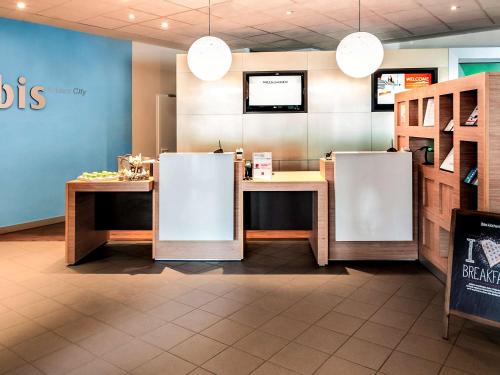 
a kitchen with a table and a refrigerator at ibis Koblenz City in Koblenz
