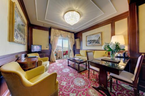 a living room with a table and yellow chairs at Hotel Splendid in Baveno