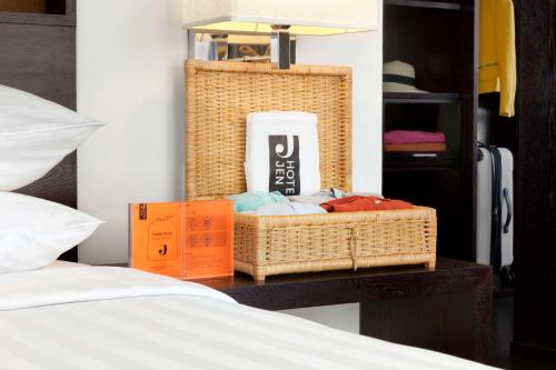 a wicker basket sitting on a table next to a bed at Jen Maldives Male by Shangri-La in Male City