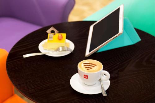 a table with a cup of coffee and a laptop at Jen Maldives Male by Shangri-La in Male City