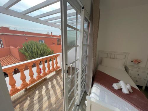 - une chambre avec un balcon, un lit et une fenêtre dans l'établissement Apartamento Gustamar 11, à Caleta de Fuste