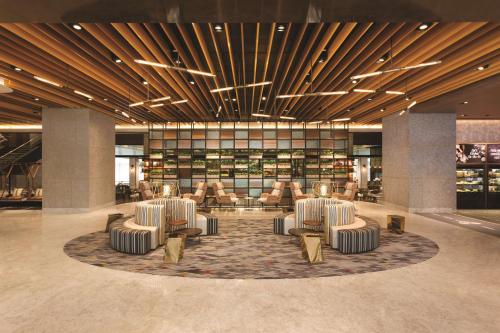 a lobby with a group of chairs and books at JEN Singapore Tanglin by Shangri-La in Singapore