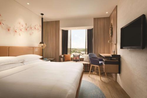 a hotel room with a bed and a desk and a television at JEN Singapore Tanglin by Shangri-La in Singapore