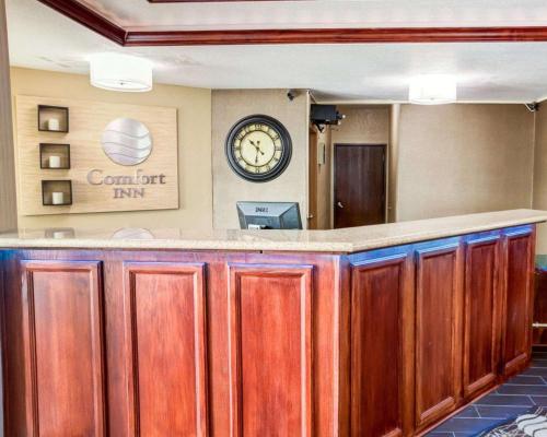 a bar in a hotel room with a clock on the wall at Comfort Inn Kearney - Liberty in Kearney