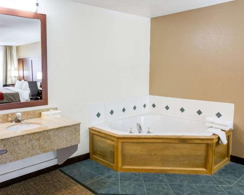 a bathroom with a tub and a sink and a mirror at Comfort Inn Kearney - Liberty in Kearney
