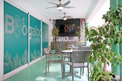 a dining room with tables and chairs and plants at Hotel Boogaloo - Adults Only in El Arenal