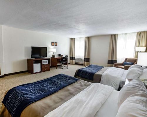 a hotel room with two beds and a flat screen tv at Comfort Inn Kearney - Liberty in Kearney