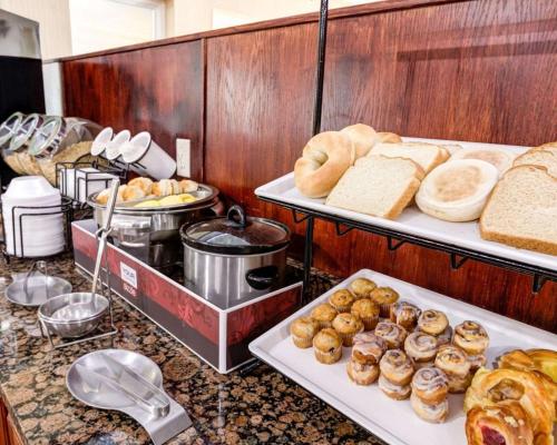 a buffet line with various types of bread and pastries at Comfort Inn Kearney - Liberty in Kearney