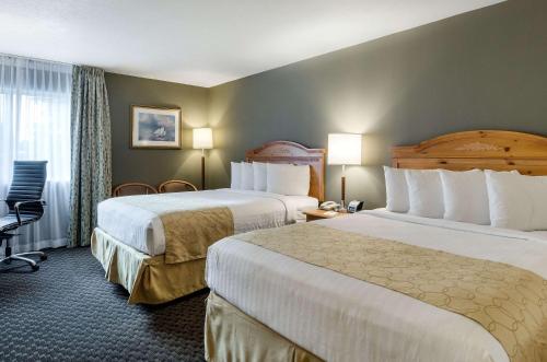 una habitación de hotel con 2 camas y una silla en Clarion Hotel Seekonk - Providence en Seekonk