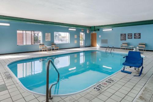 a large swimming pool with a blue chair in a room at Comfort Inn & Suites in Emporia