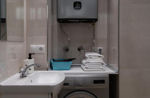 a bathroom with a washing machine and a sink at Júpiter Suites by Kaarina in Benalmádena