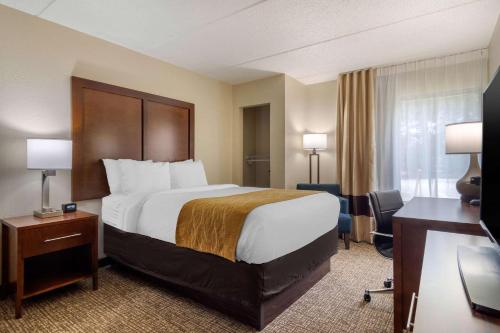 Habitación de hotel con cama grande y escritorio. en Comfort Inn Atlanta Airport en Atlanta