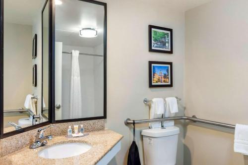 ein Badezimmer mit einem Waschbecken, einem WC und einem Spiegel in der Unterkunft Comfort Inn Atlanta Airport in Atlanta