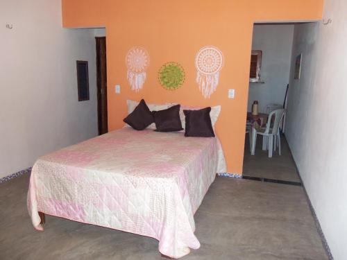 CHALÉ COQUEIROS في إيكابوي: غرفة نوم مع سرير مع لحاف وردي