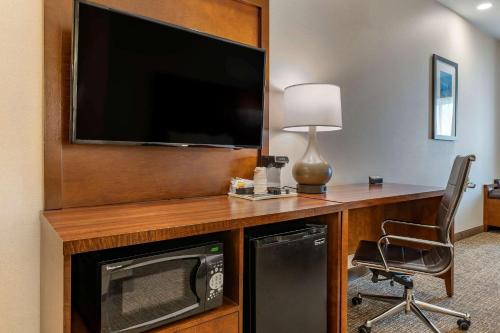 a room with a television and a desk with a chair at Comfort Suites Columbus Airport in Columbus