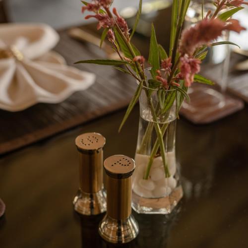 a vase with flowers in it on a table at Aalia Jungle Retreat and Spa, Bandarjudh, Haridwar - Araiya Anthology in Dehradun