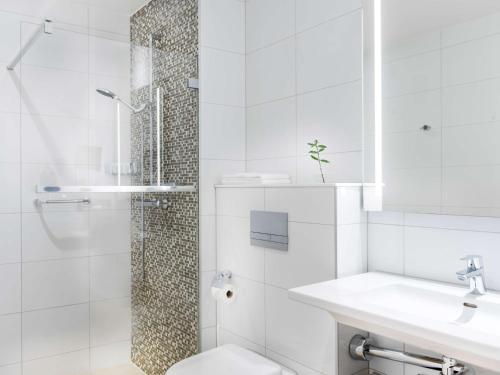 uma casa de banho com um chuveiro, um WC e um lavatório. em Radisson Blu Airport Terminal Hotel em Arlanda