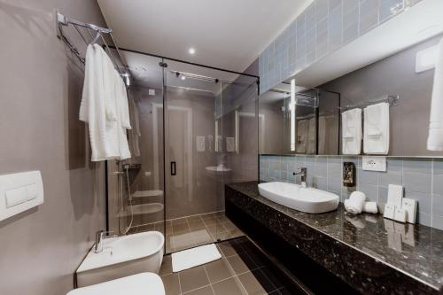 
a bathroom with a sink, toilet, and shower stall at Habitat Hotel Tirana in Tirana
