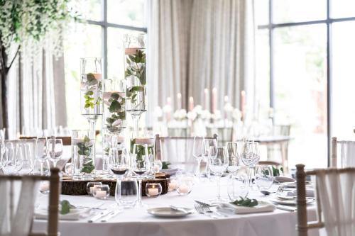 a table with glasses and plates on it with a table cloth at Rookery Hall Hotel & Spa in Nantwich