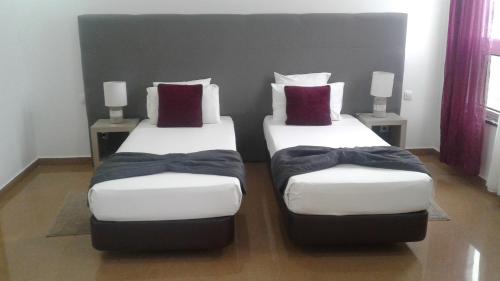 two twin beds sitting in a room with pillows at Vista Mar in Tarrafal