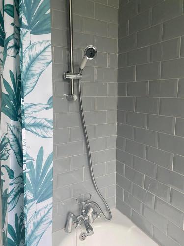 a shower with a shower head in a bathroom at Grace Stays in Ellesmere Port