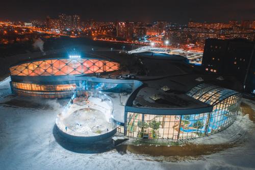 un edificio en la nieve con una ciudad por la noche en ЛетоЛето Термал Резорт & СПА, en Tyumen