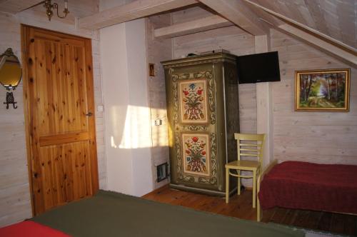 a bedroom with a bed and a cabinet and a door at Dom pod kogutem in Laliki