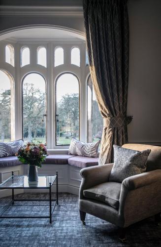 a living room with a chair and windows at Rookery Hall Hotel & Spa in Nantwich