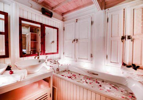 a bathroom with a tub with rose petals on the floor at Dar Cherazade & spa in Essaouira