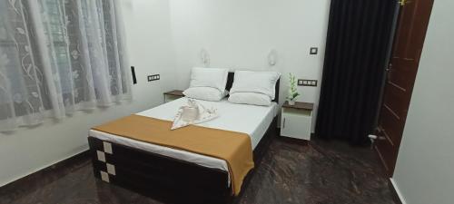 a bedroom with a bed with white sheets and pillows at Telma Beach Homestay in Mararikulam