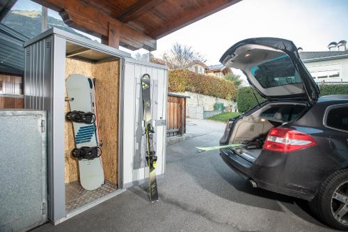 a car with its trunk open and snowboards in a garage at Apart Dahoam in Wiesing