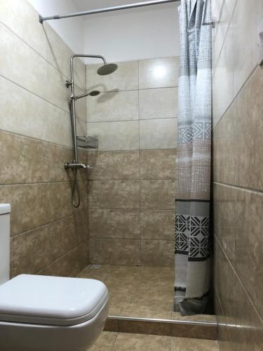 a shower with a toilet and a shower curtain at Villa Prana île Maurice in Grand Baie