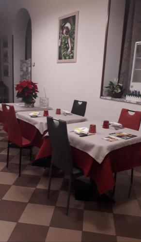 a dining room with a table and red chairs at Da Santo Hotel Ristorante Pizzeria in Ferrara