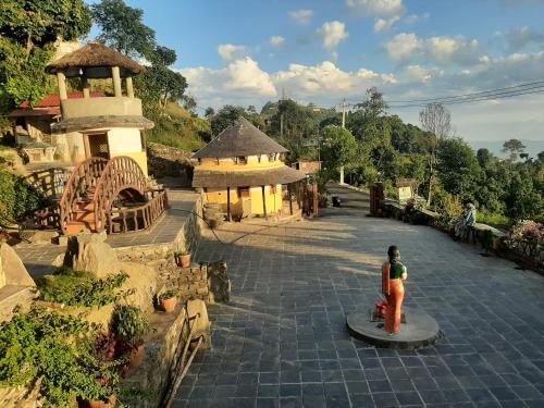 a woman standing in front of a building at Dulcify cottage sarangkot in Pokhara