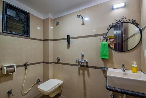 a bathroom with a sink and a mirror and a toilet at SaffronStays Ocean Breeze, Guhagar in Guhagar