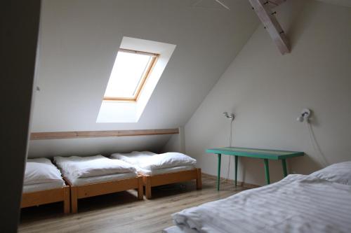 a room with two beds and a table and a window at Penzion Krizky in Malá Skála