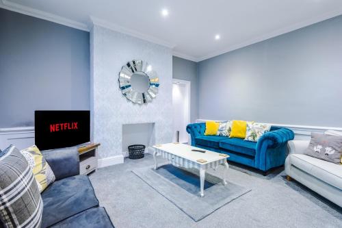 a living room with a blue couch and a table at Augustus House in Chester