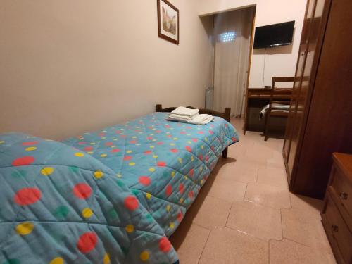 a bedroom with a bed with a blue comforter at Hotel La Rocca in Roccapalumba