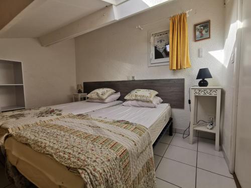 une chambre avec un grand lit dans une pièce dans l'établissement Les Lavandines -Coquette Maison de Vacances - 400 m de la plage - Grande Terrasse - 2 chambres - 2 salles de bain - Tout confort, à Argelès-sur-Mer