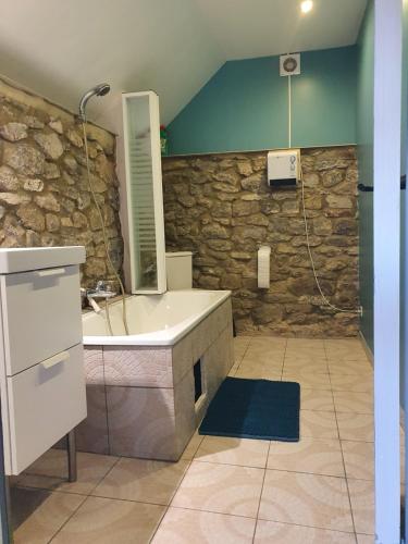 a bathroom with a sink and a stone wall at Au pti fayt in Barbençon