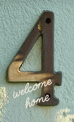 a metal number on a wall with the words welcome home at Iras in Samos